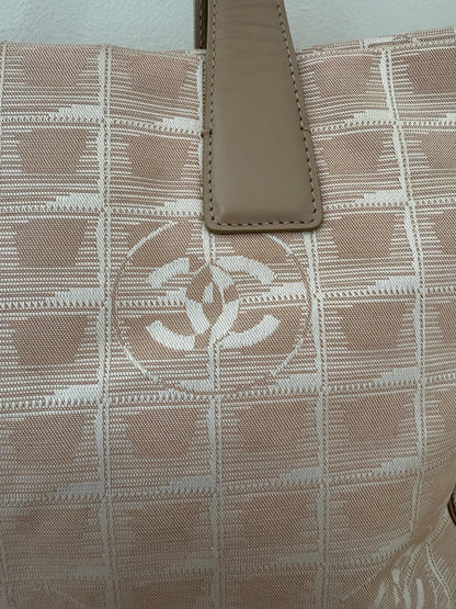 AUTHENTIC Chanel Travel Line tote bag in a blush pink nylon canvas with beige leather trim and straps