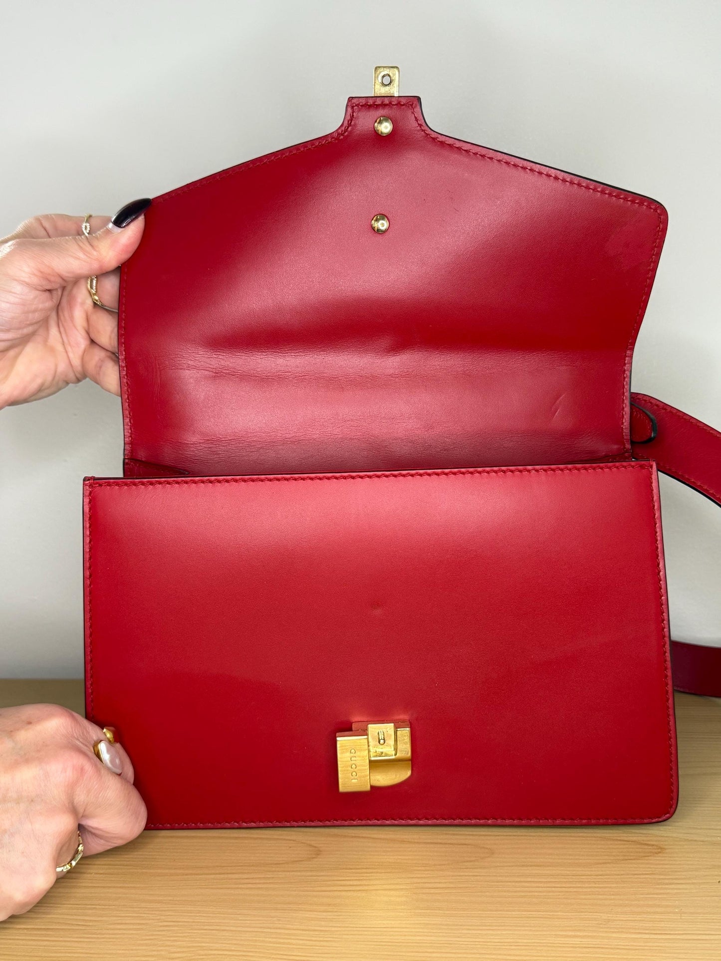 AUTHENTIC Gucci Red Leather Sylvie Sholuder Bag with gold-tone chain and buckle hardware.
